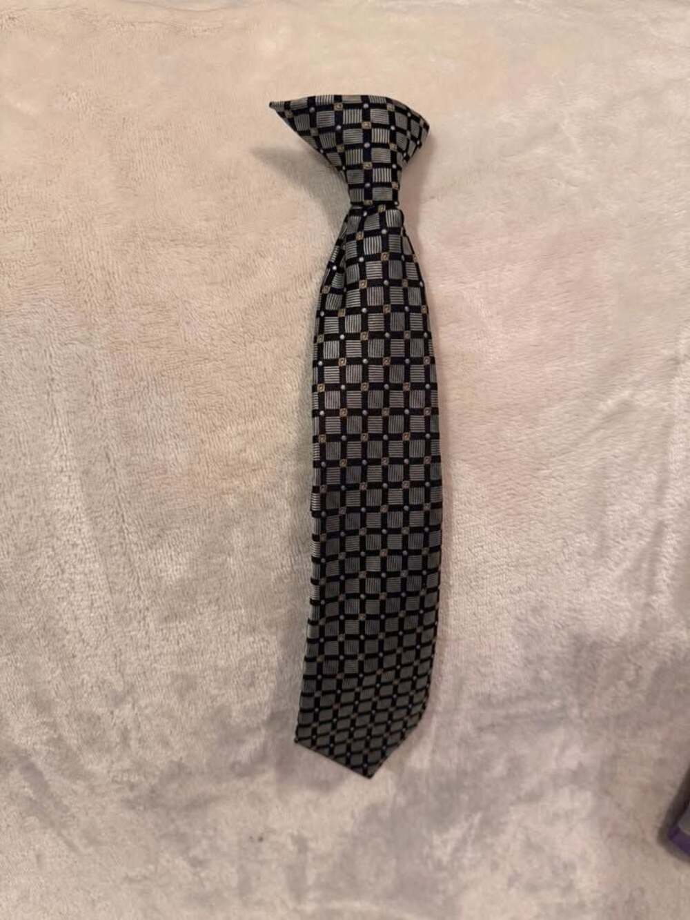 Boys clip-on necktie has a black silver gold checkered pattern 10”